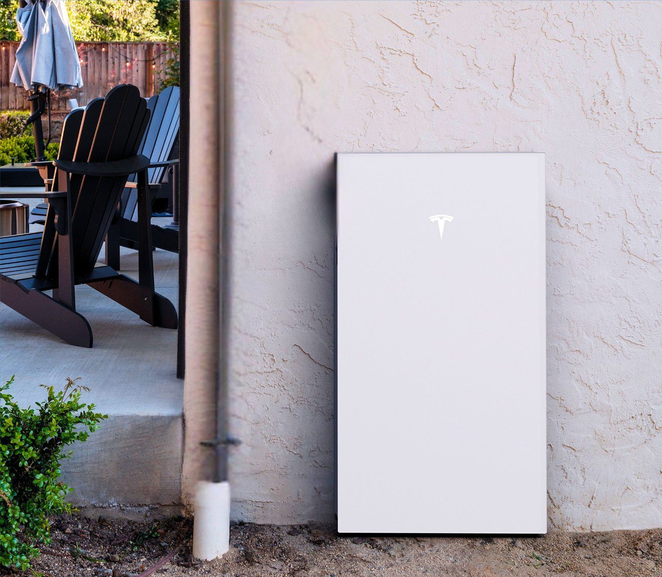 Home battery backup unit installed beside a residential patio
